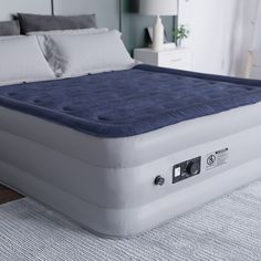 an inflatable mattress is on the floor next to a night stand and nightstand