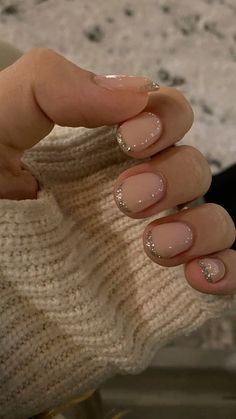 a woman's hand with french manies and gold glitter on it