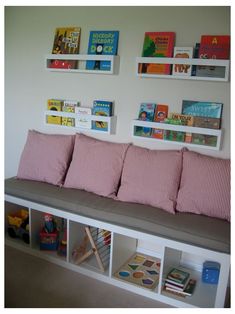 there is a bench with books on the wall above it and some shelves below it