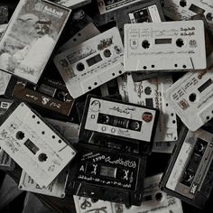 a pile of old and used cassettes are piled on top of each other in black and white