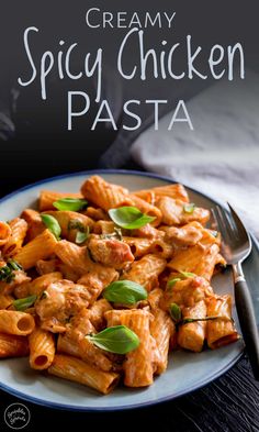 creamy spicy chicken pasta is served on a plate with a fork and napkin next to it