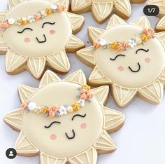 decorated cookies in the shape of cats with flowers on their heads and eyes are displayed next to each other