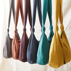 six different colored bags hanging on a white wall