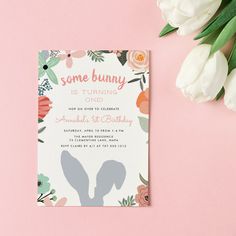 some bunny is turning one birthday card on a pink background with flowers and tulips