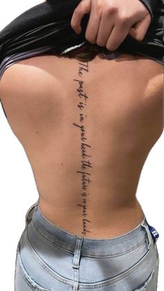 the back of a woman's body with writing on her lower and upper back