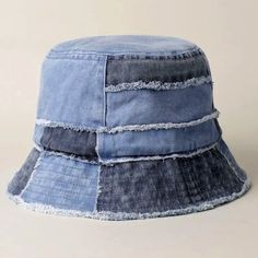 a blue jean bucket hat with fraying on the front and sides, against a white background