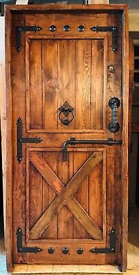 an old wooden door with metal handles and latches on the front, sitting in a room