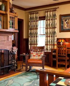 a living room filled with furniture and a fire place next to a window covered in curtains