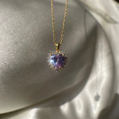 Add a touch of regal elegance to your jewelry collection with this Purple Royal Heart Necklace. The tiny violet halo pendant is made of non-tarnish 925 sterling silver, making it a durable and affordable choice for a love-themed gift. The purple color adds a touch of whimsy and femininity to any outfit, making it perfect for any occasion. Whether you're dressing up for a night out or just want to add a pop of color to your everyday look, this Purple Royal Heart Necklace is the perfect choice. Bu Yellow Gold Heart-shaped Jewelry With Halo Setting, Yellow Gold Heart Jewelry With Halo Setting, Heart-shaped Yellow Gold Jewelry With Halo Setting, Yellow Gold Jewelry With Heart Shape Halo Setting, Purple Cubic Zirconia Jewelry For Valentine's Day, Purple Heart Cut Cubic Zirconia Jewelry, Valentine's Day Halo Cubic Zirconia Jewelry, Valentine's Day Cubic Zirconia Halo Jewelry, Elegant Lavender Hallmarked Jewelry