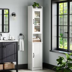 a bathroom with a sink, mirror and cabinet next to a window in the room