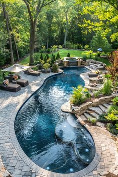 an outdoor swimming pool surrounded by stone steps and patio furniture, with seating around it