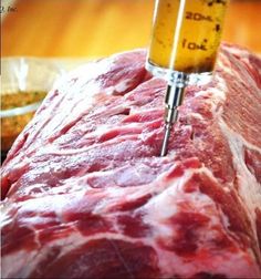 a large piece of meat on a cutting board with a needle in the middle of it