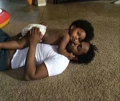 a woman is laying on the floor with her baby