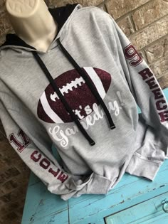 a gray hoodie with a football on it