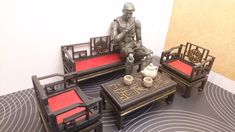 a statue sitting on top of a wooden table next to two chairs and a coffee table