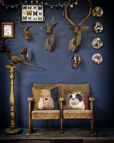 a living room with deer heads on the wall and other animal head mounted to the wall