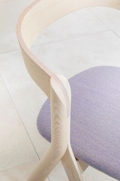 a close up of a wooden chair with blue fabric