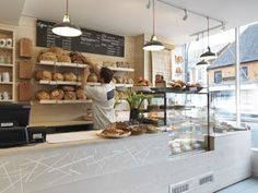 a man working behind the counter of a bakery