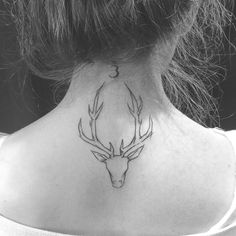 a woman's neck with a deer head tattoo on the back of her neck