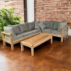 a couch and coffee table in front of a brick wall