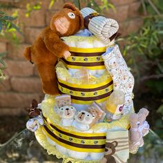 a teddy bear sitting on top of a yellow and brown cake with bears around it