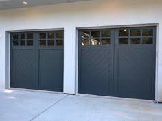 two garage doors in front of a white building