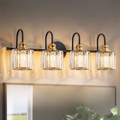 a bathroom light with three lights on the wall above it and a mirror behind it