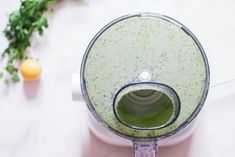 a blender filled with green liquid on top of a counter