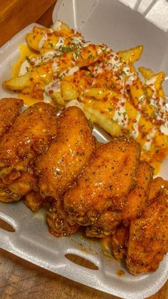 chicken wings and french fries in a styrofoam container