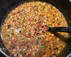 a pot filled with beans and vegetables on top of a stove