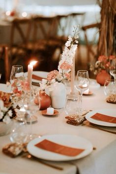 the table is set with white and orange place settings