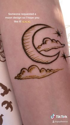 a woman's arm with the moon and clouds drawn on it