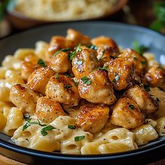 a black plate topped with pasta and chicken