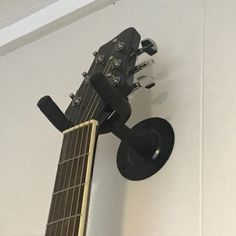 a guitar hanging on the wall with its head resting on it's back end