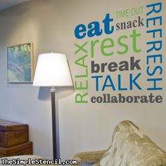 a lamp on a table in front of a wall that has words painted on it