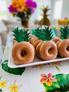 there are donuts with pineapples on the top and palm leaves on the bottom