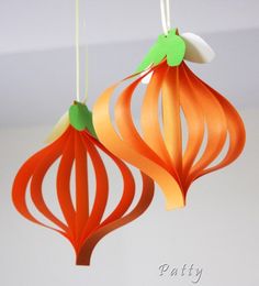 two orange and green ornaments hanging from the ceiling