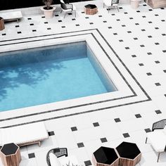 an aerial view of a swimming pool and patio furniture