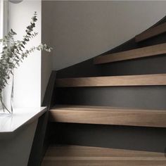 a vase filled with flowers sitting on top of a set of stairs next to a window