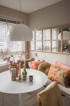 a white table sitting under a window in a living room