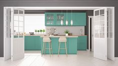 an open kitchen with two stools in front of the counter and cabinets on both sides