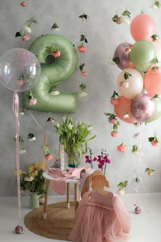 balloons are floating in the air next to a table with a chair and flower arrangement