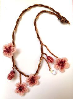 Thene of a kind asymmetrical beaded cherry blossom necklace, 100% designed and hand-crafted by me! This 40 cm unique, artisan jewelry is meant to look exactly like the magnificent spring cherry blossom branches so you can wear one on your neck and look like an ethereal nymph! It is entirely made with premium quality miyuki glass beads that they are known to made exclusively in Japan and are considered one of the most refined, luxurious tiny beads in the world! You will not wear a simple necklace. This is a piece of art made with thought, care, love, and the highest quality materials. In the personalization section, you can type the length you prefer as well as your own adjustments regarding the style of the necklace. Handmade Pink Choker As Gift, Handmade Pink Choker As A Gift, Pink Beaded Necklace With Flower Pendant, Delicate Beaded Flower Necklace, Pink Beaded Flower Pendant Necklace, Pink Beaded Flower Necklace For Gift, Handmade Pink Flower Necklace As Gift, Handmade Delicate Beaded Necklaces With Round Beads, Handmade Pink Flower Necklace Gift