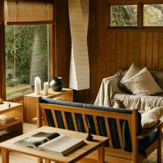 a living room filled with furniture and wooden walls