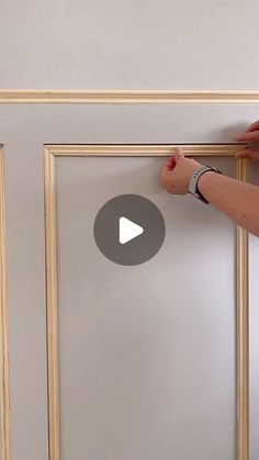 someone is painting the trim on a door with white paint and gold trimmings