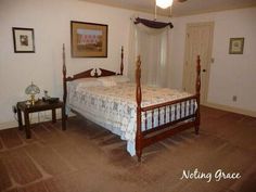 a bed room with a neatly made bed and pictures on the wall