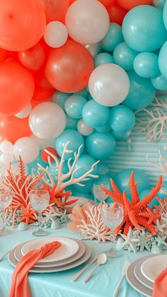 the table is set with corals, starfish and balloons