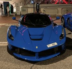 two blue sports cars parked next to each other