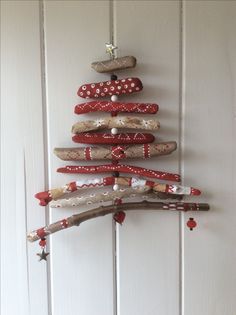 a christmas tree made out of rocks and wood sticks is hanging on the wall next to a door