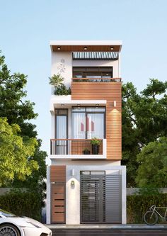 a white car parked in front of a tall building with balconies on the second floor